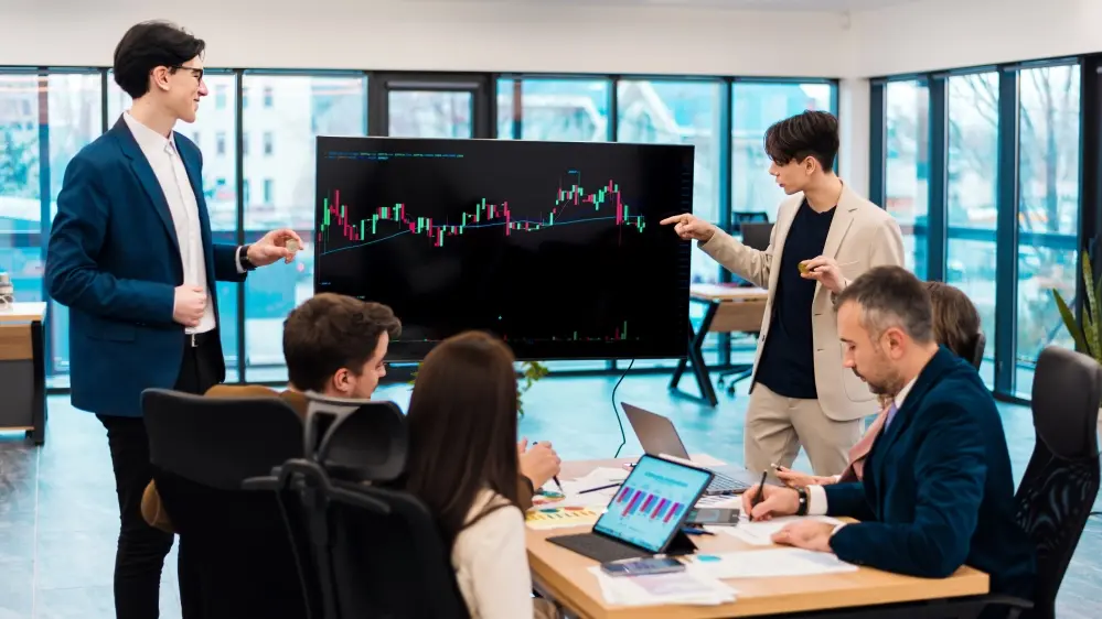 a man showing his team mate trading graph